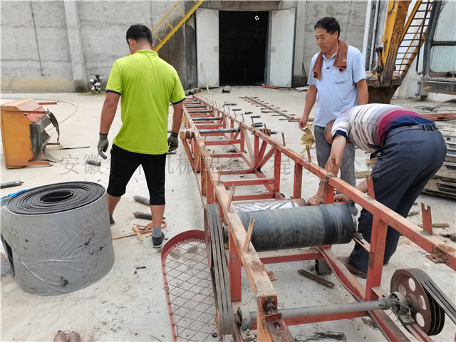 维修人员正在安装装仓伸缩移动式皮带输送机的滚筒图片